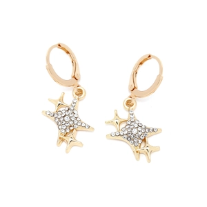 Detail of star-shaped gold earrings with paved sparkling zircons and snap closure