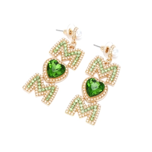 Détail de boucles d'oreilles MOM dorées avec cristal cœur vert et perles sur fond blanc