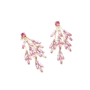 Détail de cristaux roses marquises sur des boucles d'oreilles branche dorée