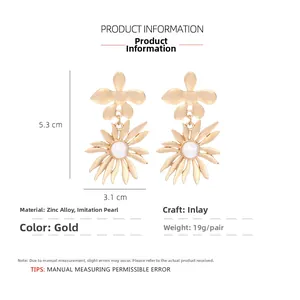 Vue détaillée des boucles d'oreilles fleur dorées avec perles et dimensions 5,3cm par 3,1cm
