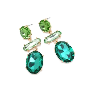 Detail of layered geometric green glass crystal earrings with golden claw settings