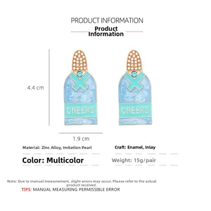 Vue détaillée des boucles d'oreilles bouteille de champagne en émail bleu clair et perles