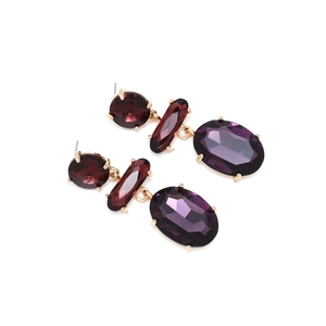Detailed macro of gold-plated drop earrings featuring three tiers of purple faceted crystals