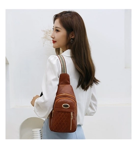 Detail of soft brown quilted leather crossbody bag with striped strap on female model