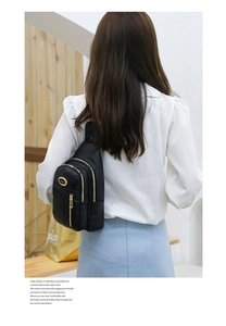 Detail of black quilted leather chest bag featuring gold zippers and diamond stitching