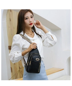Detail of black quilted crossbody bag with golden logo and colorful striped shoulder strap