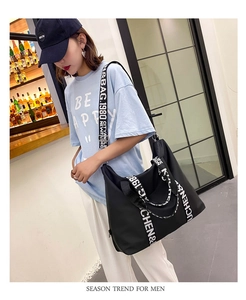Detail view of water-resistant nylon tote with letter print straps and large capacity