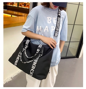 Detailed view of black nylon tote bag with high-capacity design and contrast letter straps