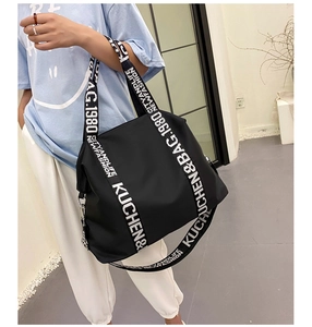 Detail of waterproof nylon tote bag with wide black and white letter print shoulder strap