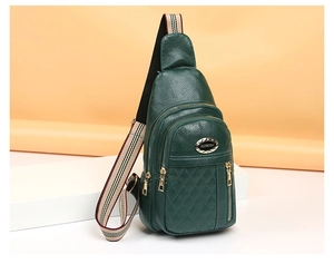 Detail of dark green quilted leather chest bag with gold zippers and striped strap