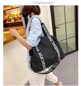 Detail of waterproof black nylon tote bag with wide logo-printed sports shoulder strap