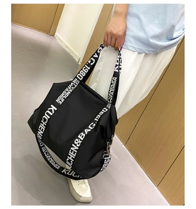 Detail of wide black strap with white lettering on waterproof nylon tote bag