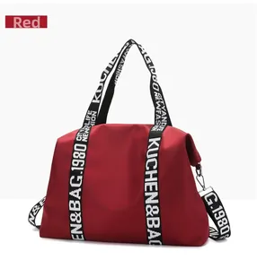 Close-up of red water-resistant nylon travel bag with contrast lettered straps