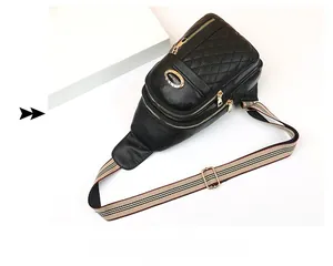 Detailed close-up of black quilted leather chest bag with golden zipper and striped strap