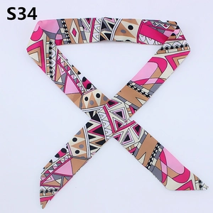 Detailed view of long satin twilly scarf with pink geometric pattern for bag handle