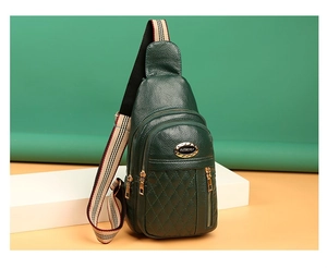 Detail of dark green textured leather chest bag with quilted pattern and gold logo plate
