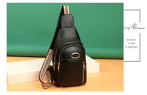 Close-up of black lychee leather chest bag with quilted stitching and striped strap