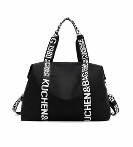 Detail of waterproof black nylon tote bag featuring white lettered straps for travel