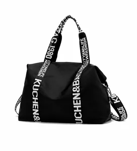 Side detail of large black nylon tote bag showing durable straps and waterproof fabric