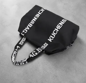 Top view of large waterproof nylon tote bag with decorative branded text straps