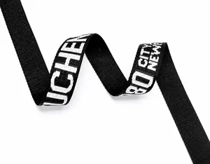 Detail view of the wide nylon shoulder strap featuring decorative white letter patterns