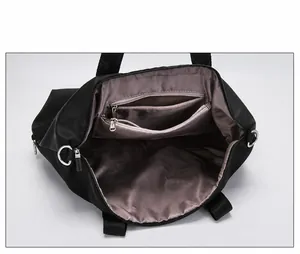 Top view showing spacious interior compartments with multiple zippers in black nylon tote bag