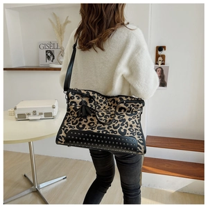 Detail of leopard print tote bag with silver studs and black fringe tassels