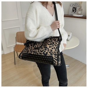 Detail of leopard print tote bag with silver rivets and elegant leather tassel charm