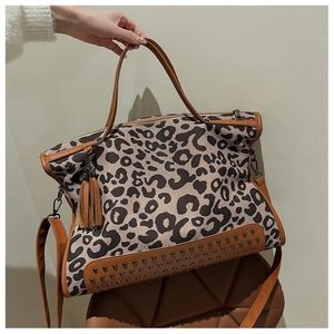 Detail view of leopard print tote bag featuring metallic rivets and leather tassels