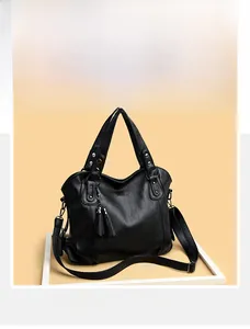 Detail einer schwarzen Tote Bag aus genarbtem Leder mit Quasten und silbernen Beschlägen