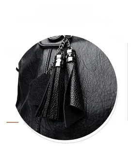Detailansicht der schwarzen Handtasche aus Narbenleder mit silbernem Quastenanhänger