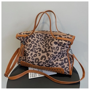 Detail of leopard print tote bag featuring metallic studs and leather fringe tassel