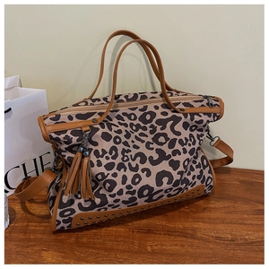 Macro view of leopard print tote bag with brown PU trim, tassels, and rivet details
