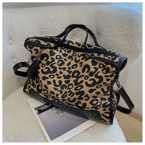 Detail of leopard print canvas tote bag featuring metal rivets and leather tassels