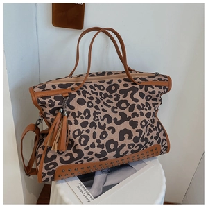 Detail of leopard print canvas tote bag with metal studs and brown leather straps