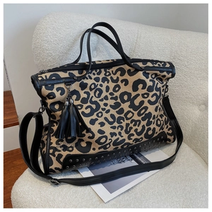 Detail of leopard print tote bag with black metal rivets and leather fringe tassel