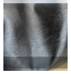 Close-up of premium black lychee-patterned leather fabric texture and glossy finish
