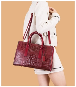 Détail du sac à main rouge foncé motif crocodile avec relief crâne et pieds en métal