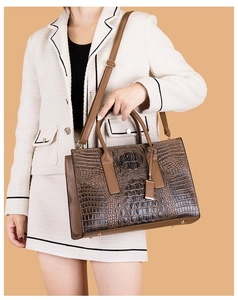 Détail du sac cabas marron à motif crocodile avec pieds métalliques et bandoulière amovible