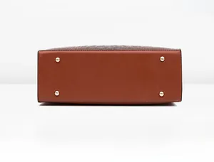 Détail du grand sac cabas marron à motif crocodile avec clous de protection dorés au fond