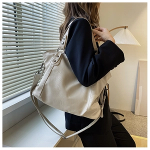 Close-up of beige large capacity tote bag with vintage metal rivets and leather texture