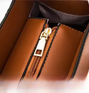 Détail de la fermeture éclair en métal doré sur le sac à main en cuir marron