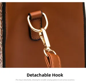 Détail du crochet doré et de la bandoulière amovible sur un sac en cuir marron