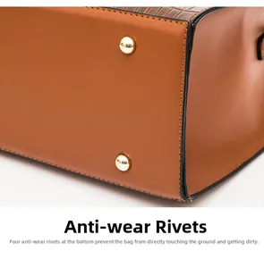 Détail du fond de sac marron à motif crocodile avec quatre rivets métalliques dorés