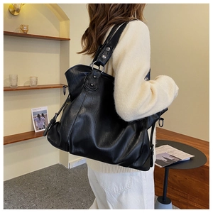 Detailed view of black faux leather texture on a large capacity shoulder tote bag