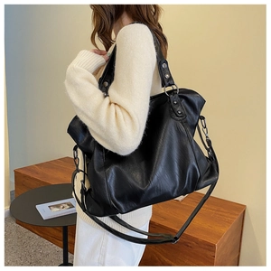 Detail of black large capacity tote bag with adjustable strap and dark silver hardware