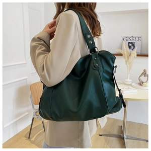Detail of dark green pebble grain tote bag with silver rivets and metal hooks