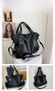 Detail view of large black faux leather tote bag with silver studs and adjustable strap