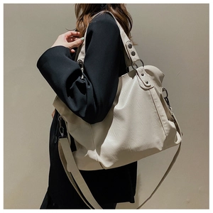 Model wearing a large beige PU leather tote bag with stylish top handle and shoulder strap