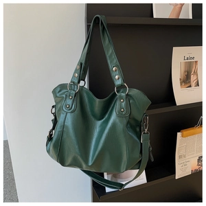 Detail of dark green tote bag featuring lychee grain leather and silver metal ring hardware
